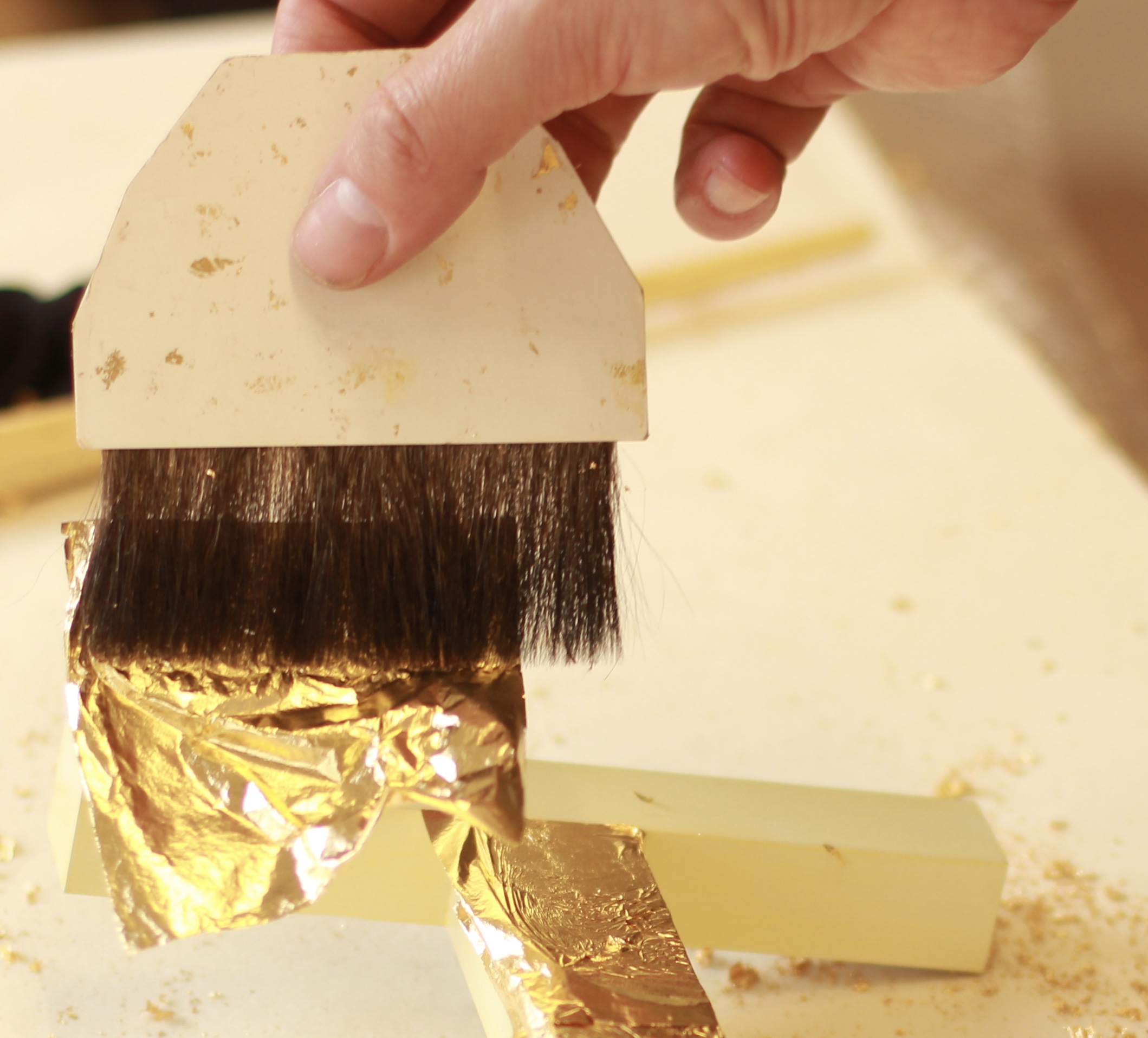 Gold leaf being laid with a gilder's tip
