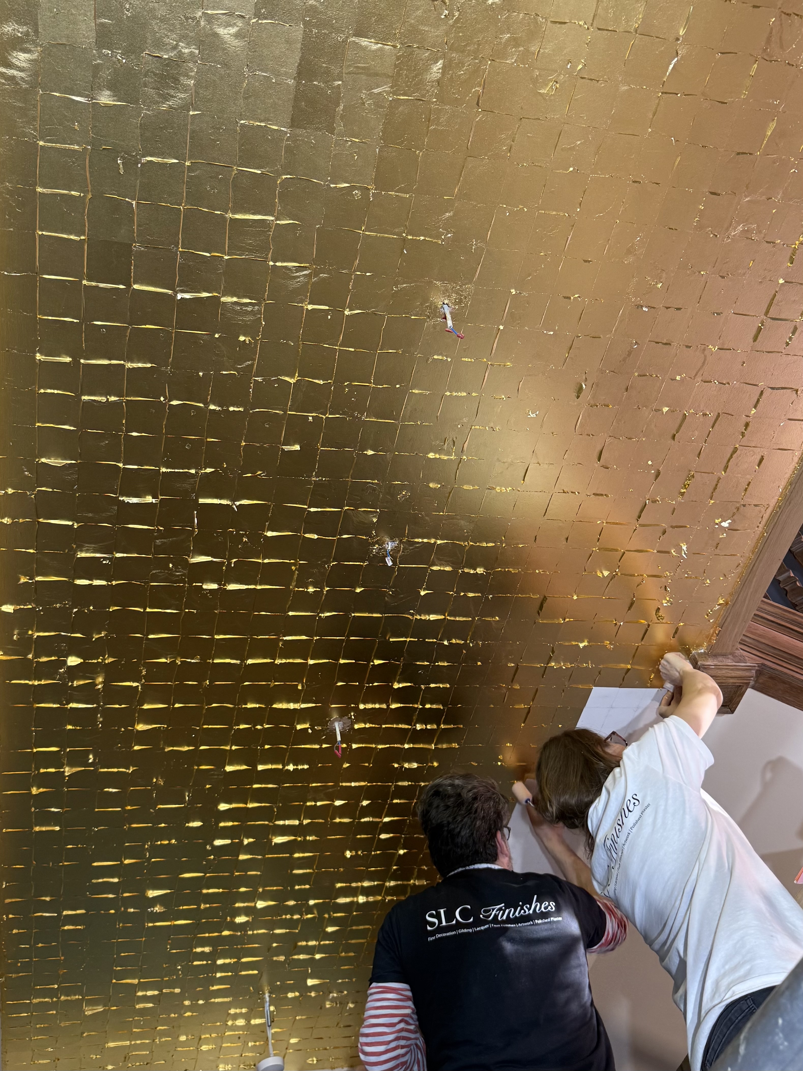 SLC Finishes gilders applying gold leaf to a large ceiling